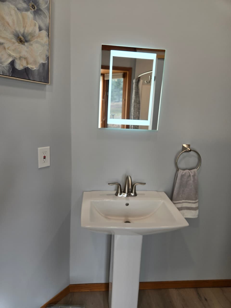 Renovated primary bath with a vanity and backlit mirror